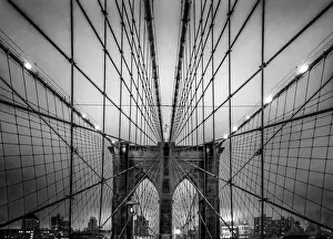 Brooklyn Bridge and Manhattan skyline at dusk under a cloud of fog in black and white