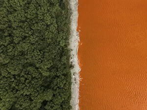 Images Dated 19th August 2023: Composed drone image showing the edge of a forest and an orange coloured salt lake
