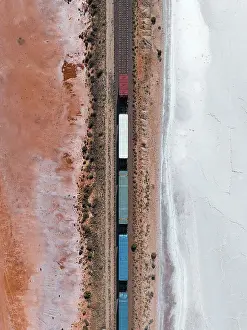 Drone image looking down on a freight train crossing a salt lake, South Australia, Australia
