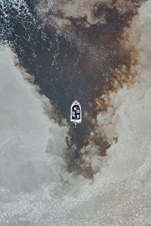 Images Dated 10th August 2023: Drone photo looking down on a speedboat between clouds of sediment flowing down the Mary River