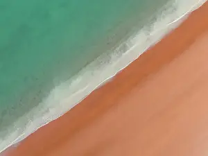 Aerial View Prints: Drone shot looking down on calm waves washing onto Simpson Beach