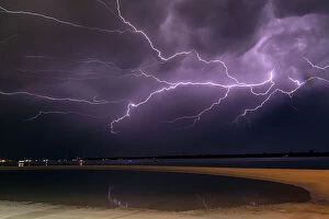 Lightning Strikes Collection: Flashes of bright lightning strikes across the water with stormy clouds and sky