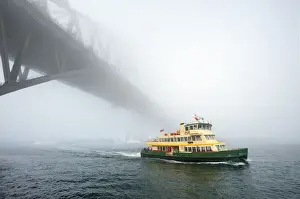 Iconic Sydney Ferry passing the Bridge on a misty day