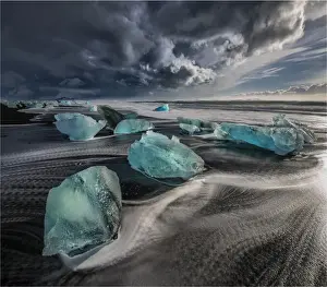 Jokulsarlon Beach in winter, just after a huge storm hit the coastline. Ice bergs from the nearby lagoon have been swept up onto the coastline and surge in and out with the tide