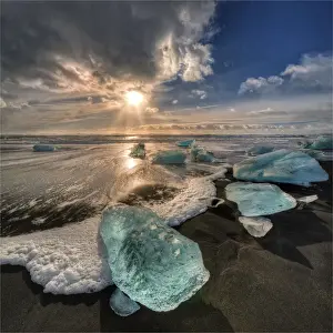 Jokulsarlon Beach in winter, just after a huge storm hit the coastline. Ice bergs from the nearby lagoon have been swept up onto the coastline and surge in and out with the tide