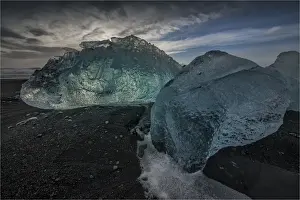 Jokulsarlon Beach in winter, just after a huge storm hit the coastline. Ice bergs from the nearby lagoon have been swept up onto the coastline and surge in and out with the tide