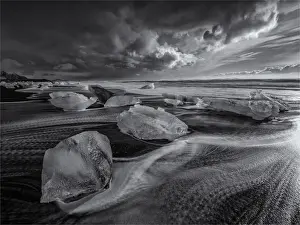 Jokulsarlon Beach in winter, just after a huge storm hit the coastline. Ice bergs from the nearby lagoon have been swept up onto the coastline and surge in and out with the tide
