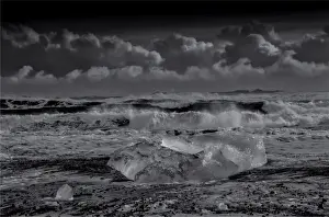 Jokulsarlon Beach in winter, just after a huge storm hit the coastline. Ice bergs from the nearby lagoon have been swept up onto the coastline and surge in and out with the tide