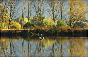 Lone fisherman with reflections of the Autumn, near Mount Beauty, in the high country of Victoria
