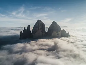 Majestic aerial shot above the clouds looking towards Tre Cime Di Lavaredo, Italy Majestic aerial shot above the clouds looking towards Tre Cime Di Lavaredo, Italy