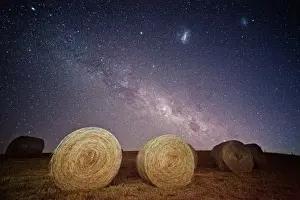 Milky way and magellanic clouds over hay bales