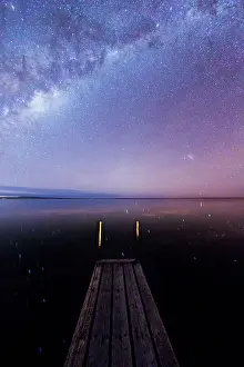 Milky Way and stars over the Proper Bay. Small wooden jetty and stars reflecting in the ocean. Port Lincoln. Eyre Peninsula. South Australia