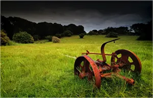 Old farm machinery lays rusting away in a farm paddock near Wybalenna, Flinders Island Tasmania