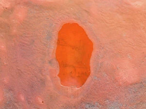 Images Dated 10th August 2023: Oval shaped pool of water in an iron mine shot from a drone perspective, Western Australia