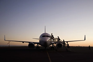 People boarding an airplane at dusk, Port Hedland, Western Australia, Australia