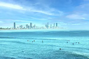 Vicki Smith Australian Landscape Photography Prints: People surfing in the blue ocean waters of the Gold Coast with city skyline