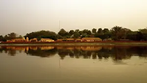 River Gambia at sunset with Tendaba settlement reflections on calm water during sunset
