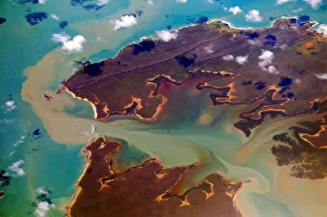 <b class=qtipBold><figcaption>Sediment laden waters</figcaption></b><br>Seawaters off mainland coast of Australia, showing varying degrees of sediment load spread around jagged coastline by nearshore currents. Turbulence and local river flooding caused in aftermath of Cyclone Ita which passed this area in April 2014.<br><em>© 2014 Michael Thirnbeck</em> Sediment laden waters