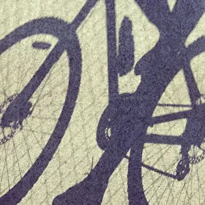 Jodie Griggs Prints: Shadows on concrete of person riding on a bicycle