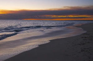 A smokey sunset on the beach after the bushfires creates a glorious red sky