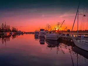 A summer dawn light castes a glow over the boats and harbour area at Lakes Entrance, East Gippsland