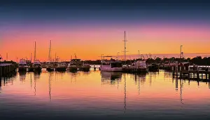 A summer dawn light castes a glow over the boats and harbour area at Lakes Entrance, East Gippsland