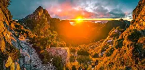 Sun rising up behind the Lions Head and Franklin River Basin on the way up to Fanchmens Cap (left and right rock walls)