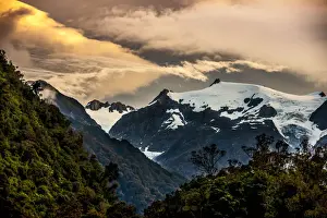 Prints of A serene sunset over the mountains and Franz Josef glacier, located in the center of the picture New Zealand Prints: The sun setting over the Franz Josef glacier located on the south island of New Zealand