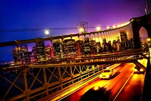 A tilted view of a yellow cab speeding along the Brooklyn Bridge at dusk A tilted view of a yellow cab speeding along the Brooklyn Bridge at dusk