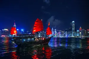 Sail Prints: A Traditional Chinese Junk Sailing In Victoria Harbour With View of Hong Kong Island Skyline At Night