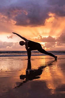 Fine Art Photography Collection: Woman doing Yoga on the beach at sunrise